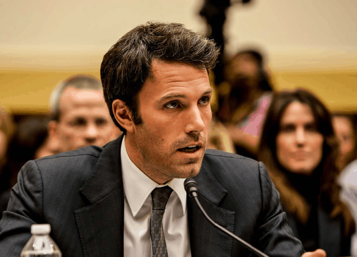 Ben Affleck, wearing a suit, speaks into a microphone in a U.S. Senate committee room.